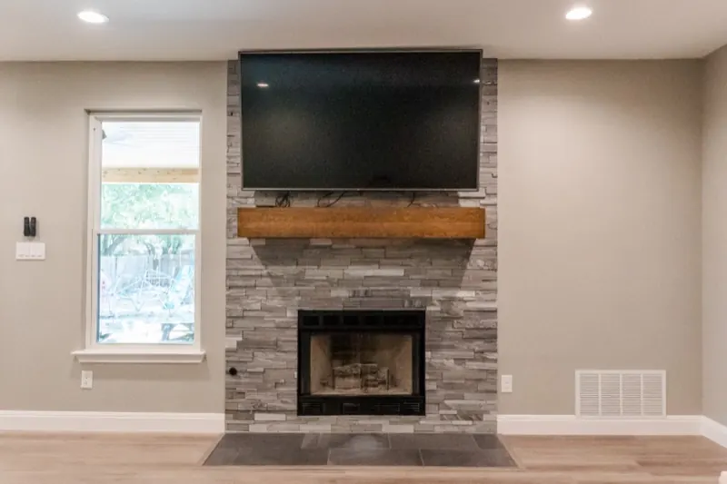 Remodeled living room with stacked-stone fireplace in Austin, TX