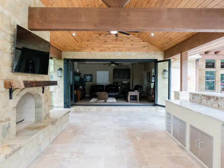 Outdoor living pavilion with stacking glass doors opening to the home