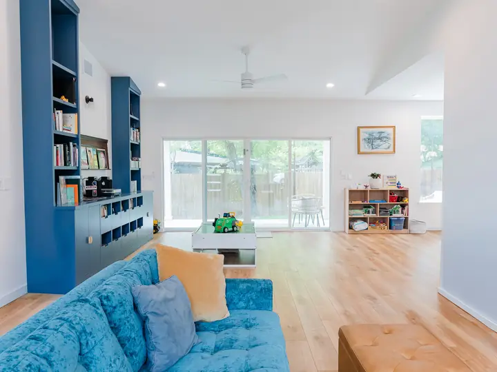 Living room with built-in navy bookshelves and white oak floors