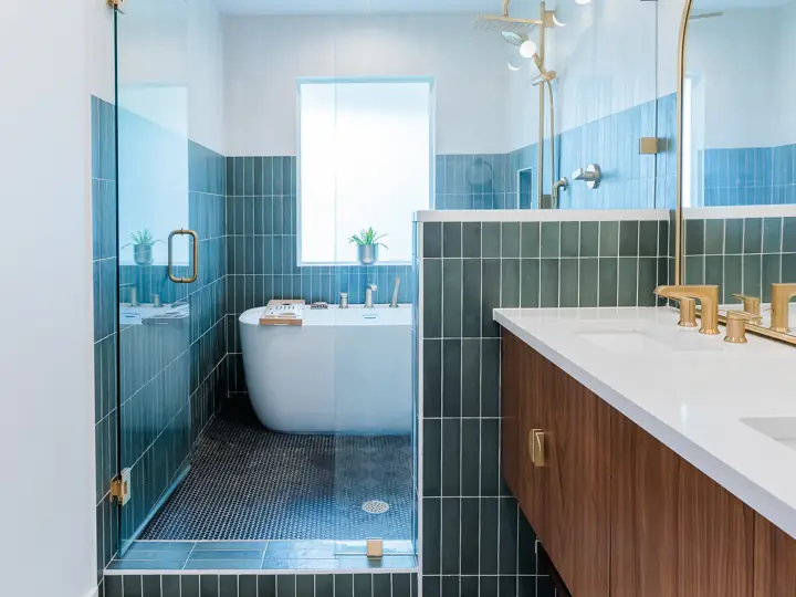 Primary bathroom with glass shower, soaking tub, and green tile