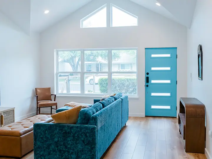 Vaulted living room with clerestory windows and teal front door