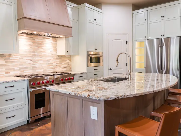 Kitchen island with granite counters and professional range in Lakeway, TX