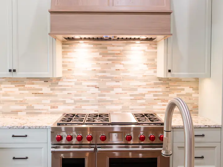 Professional range with custom wood hood and stone backsplash