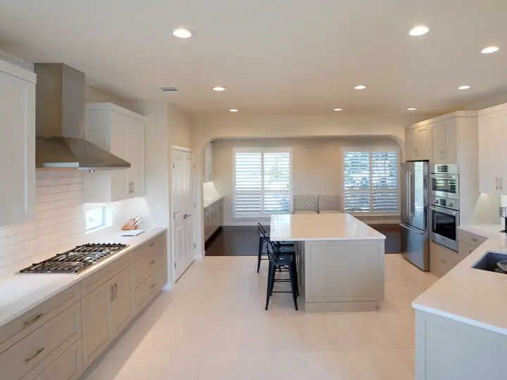 Kitchen remodel with white cabinets, subway tile, and stainless range hood