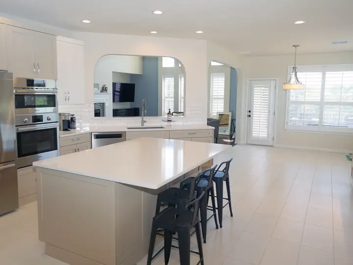 Open-concept kitchen remodel with large quartz island and stainless appliances