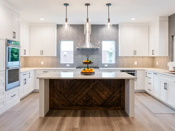 White kitchen remodel with herringbone wood island and stainless range hood