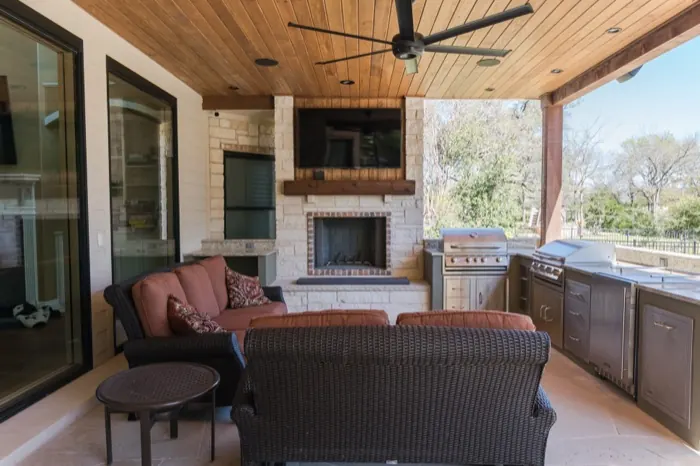 Covered outdoor living area with stone fireplace in Austin, TX